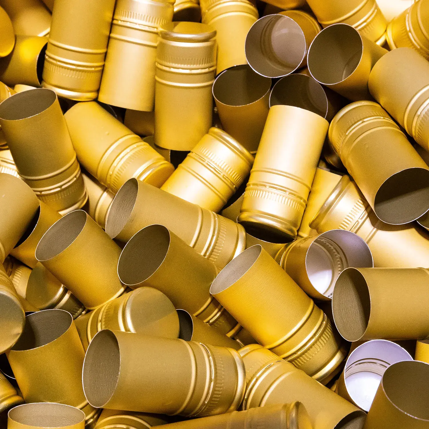 Der bimalo Goldstandard: Exzellenz und Klarheit von der ersten Idee bis zum Verschluss. Nahaufnahme goldener Verschlusskapseln auf bimalo Cider-Flaschen als Zeichen für höchste Qualitätsstandards und Exzellenz in jedem Schluck.