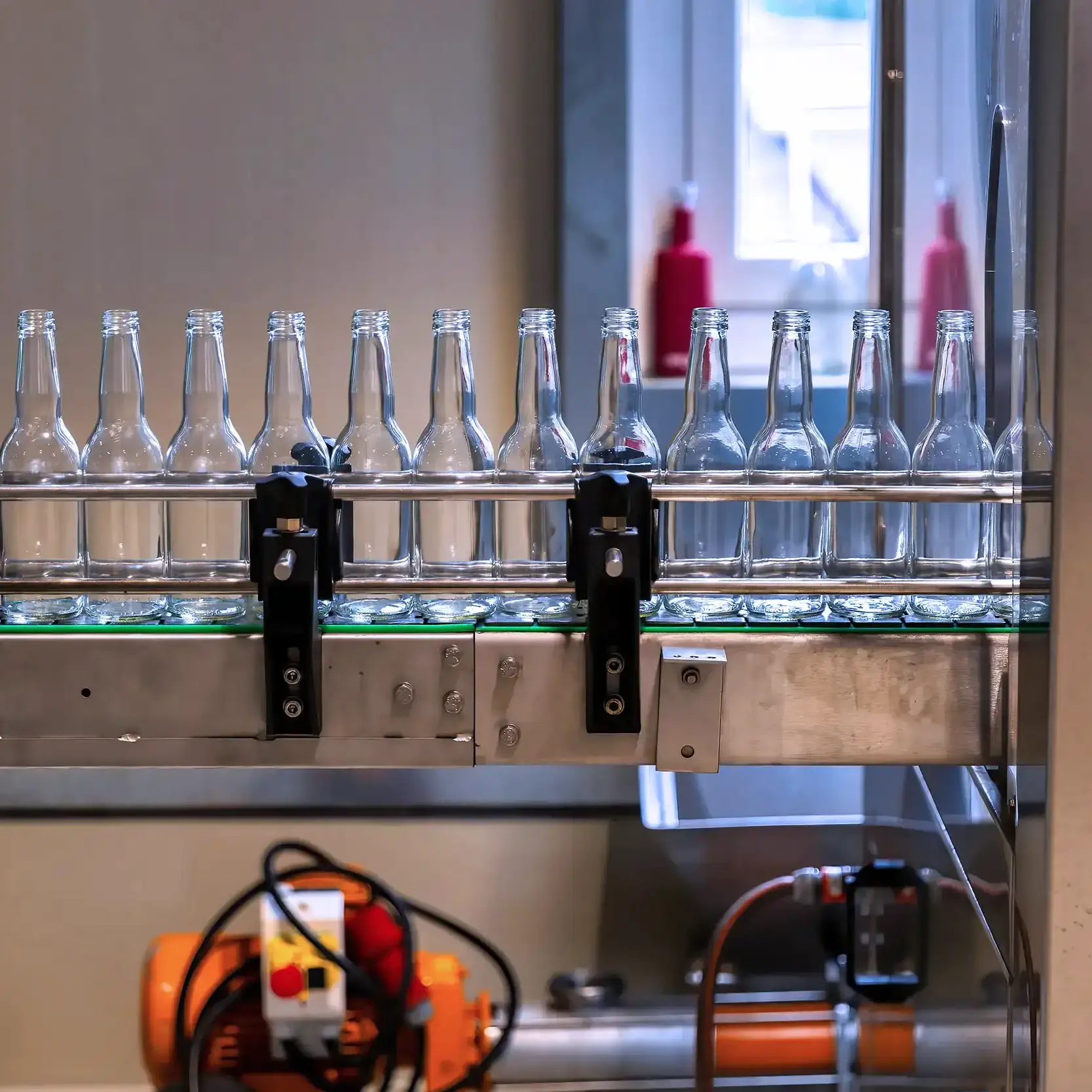 Laufendes Förderband mit gefüllten Flaschen auf der Abfüllanlage bei bimalo – präzise Fertigstellung Ihrer Getränkecharge.