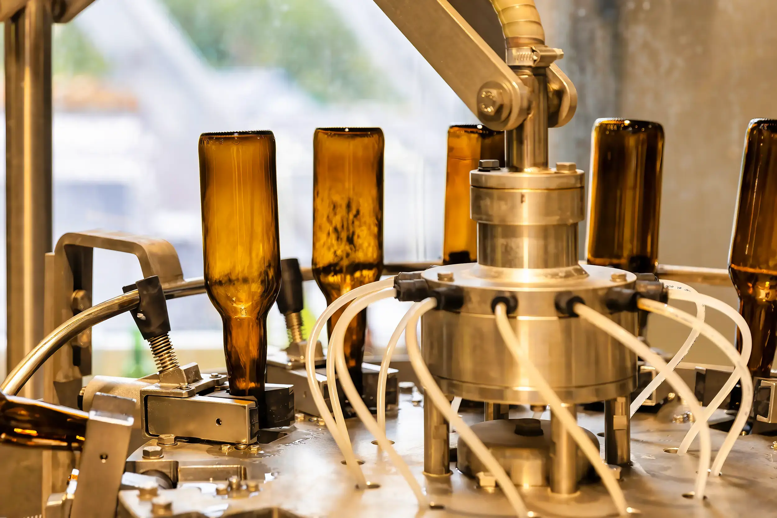 Professionelle Reinigung von Glasflaschen in der Flaschenwaschanlage der Brauerei Wolfsegg für maximale Hygiene bei der Lohnbrauung.